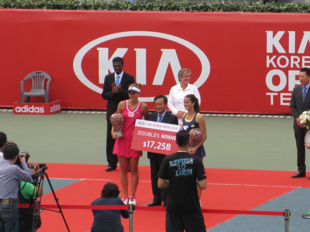 Doubles champions Irina-Camelia Begu and Lara Arruabarrena with the Kia representative